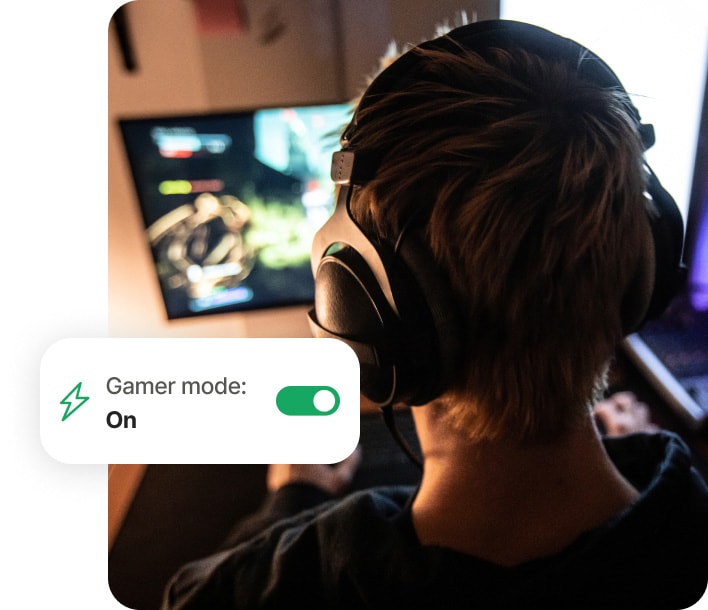Pojke som spelar spel på dator och använder Norton 360 for Gamers.