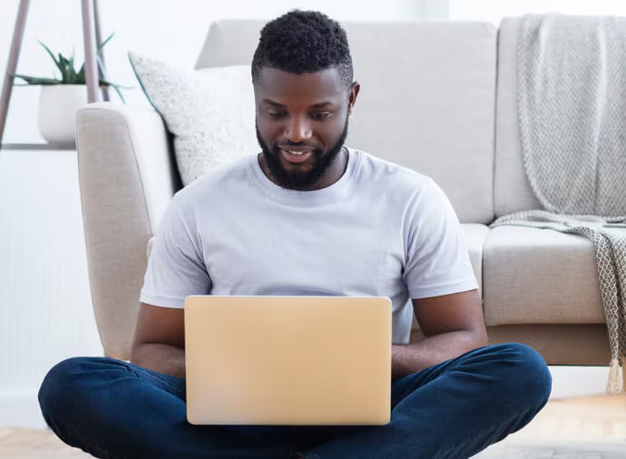Sittande man som använder en laptop